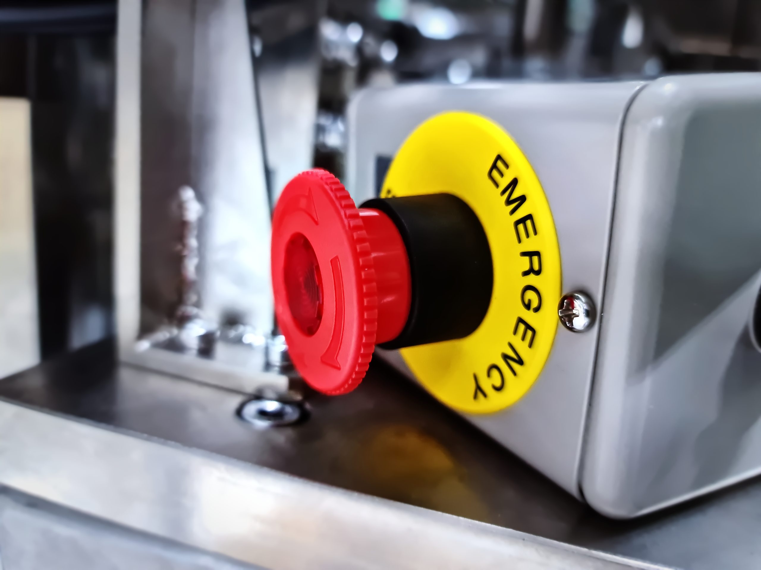 Close-up Emergency Button Against Blurred Machine Background